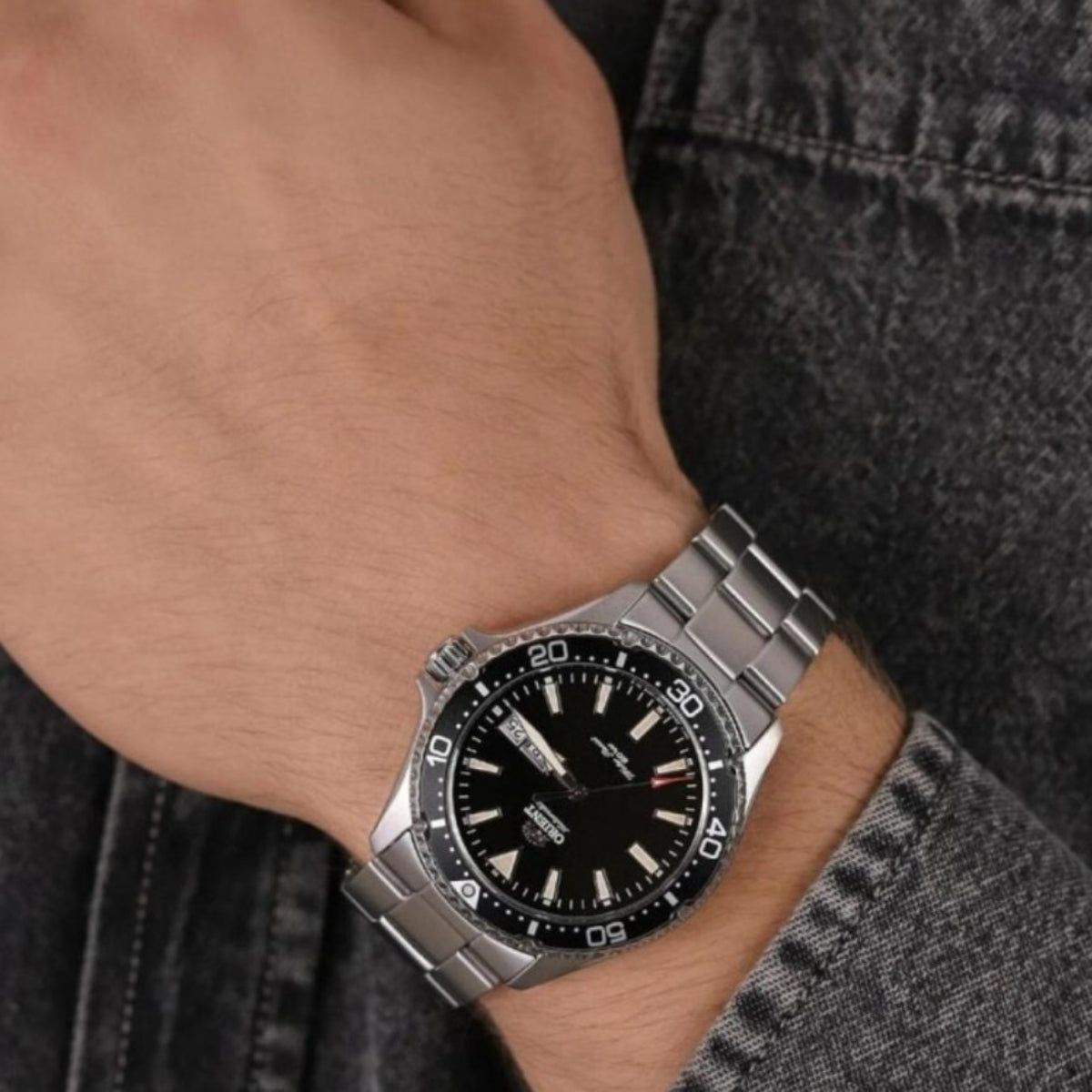 Orient Kamasu Mako III RA-AA0001B39B automatic sports watch with a black dial and steel link bracelet worn on a mans wrist.