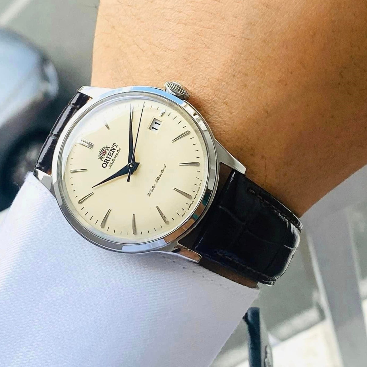 Orient Bambino RA-AC0M04Y30B mens automatic watch on wrist, champagne dial with date window, brown leather strap