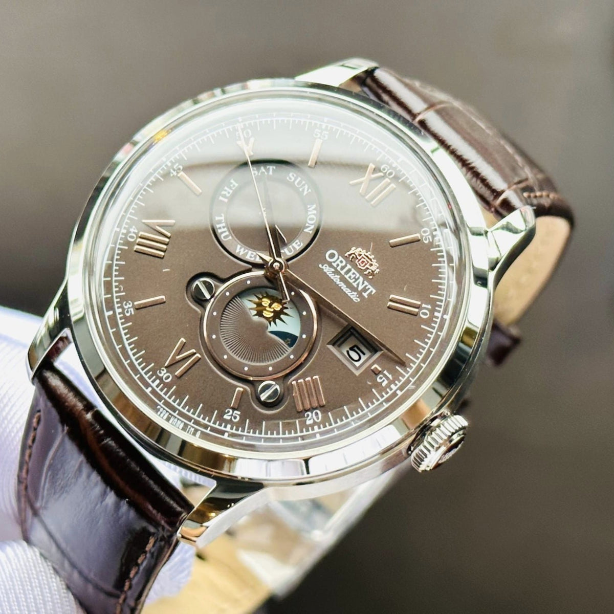 Orient Bambino Sun & Moon RA-AK0804Y30B automatic watch with brown sun-moon dial, gold accents, and dark brown leather strap