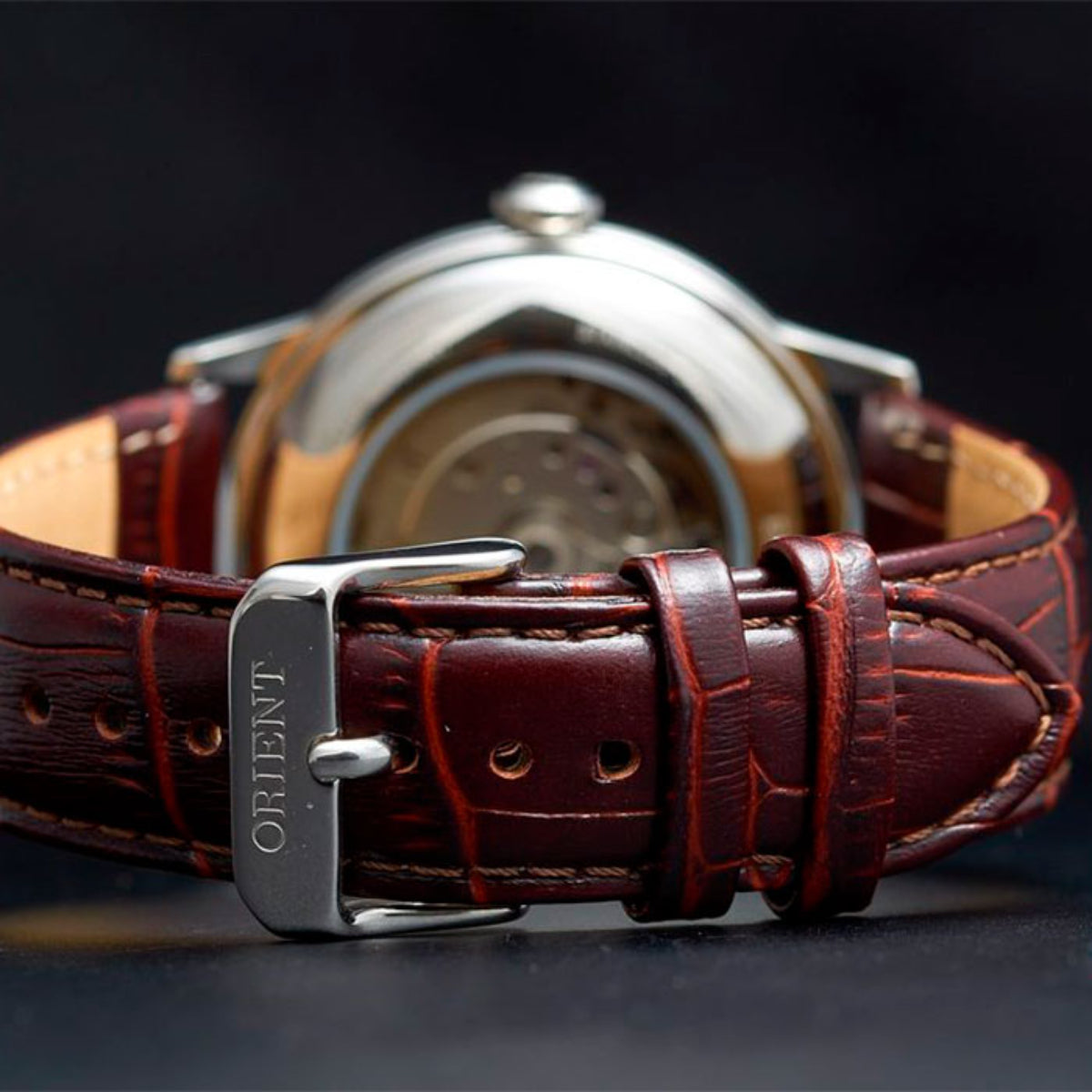 Men's automatic watch with brown leather strap, silver buckle, and case back