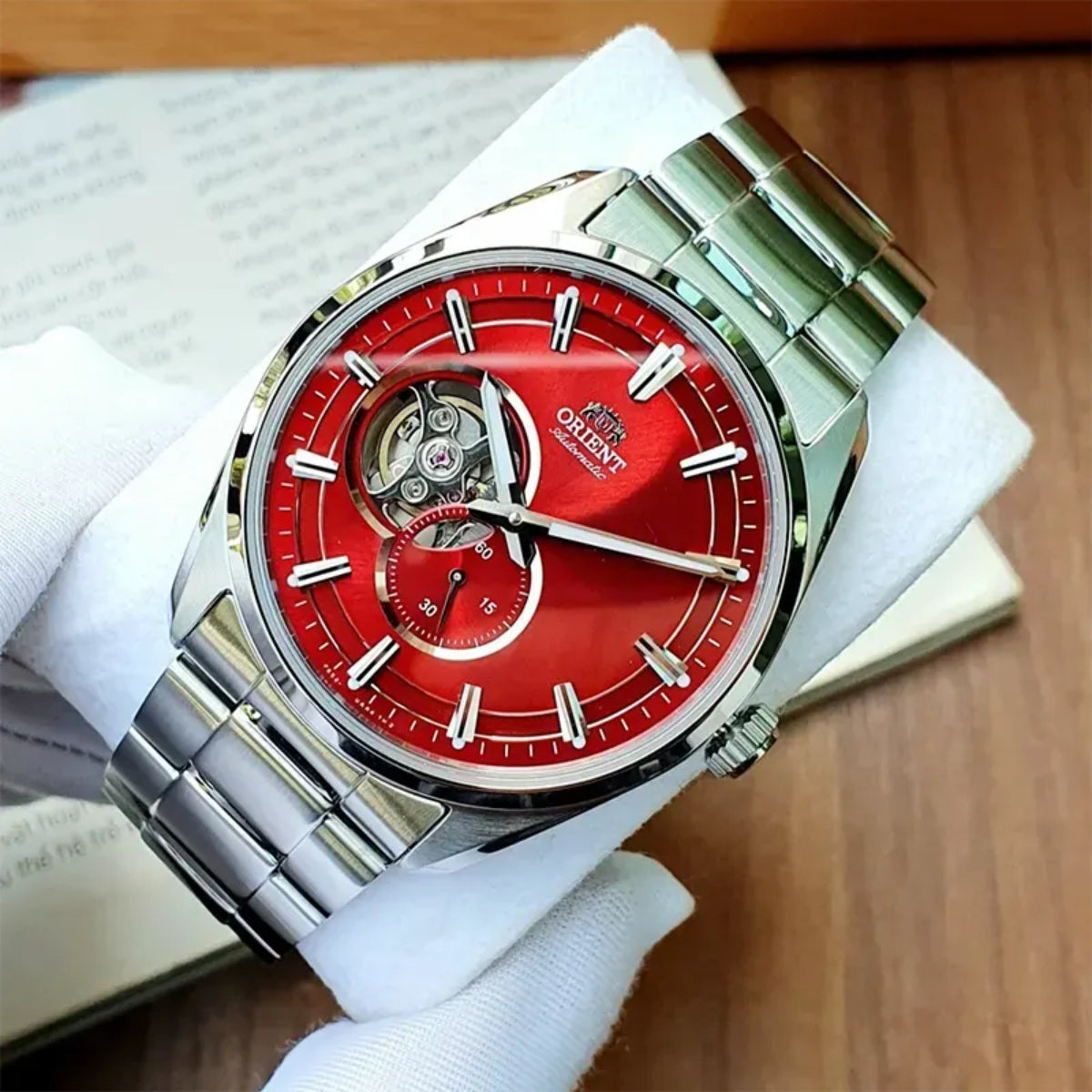 Men’s steel automatic watch with red dial and open-heart window on the wrist