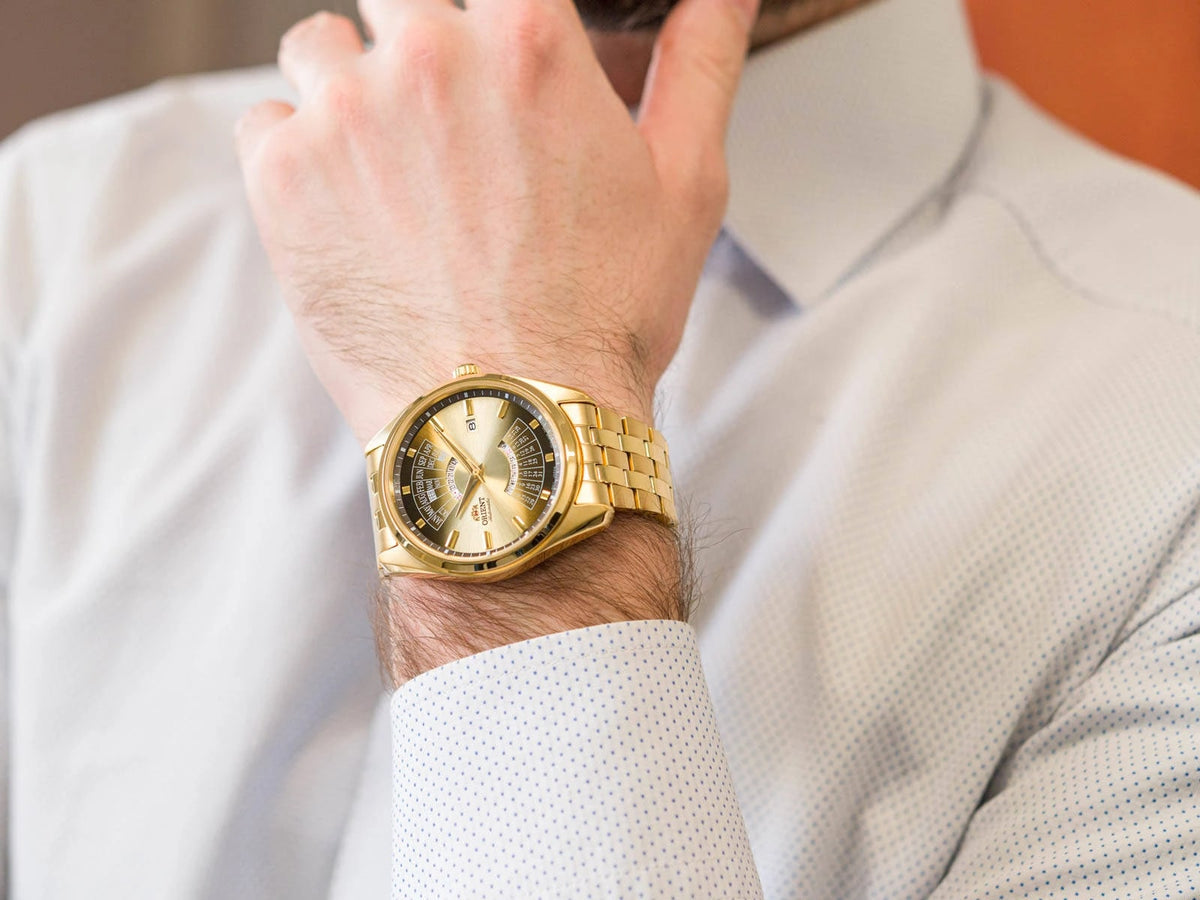 Men's automatic watch on wrist, champagne dial with gold-tone steel bracelet and date