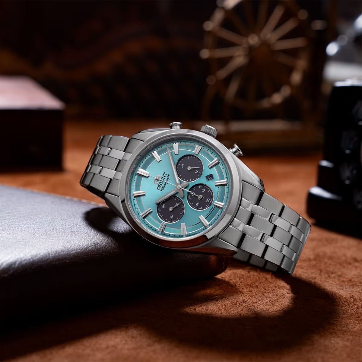 Solar chronograph wristwatch with light blue dial and steel bracelet, angled view.