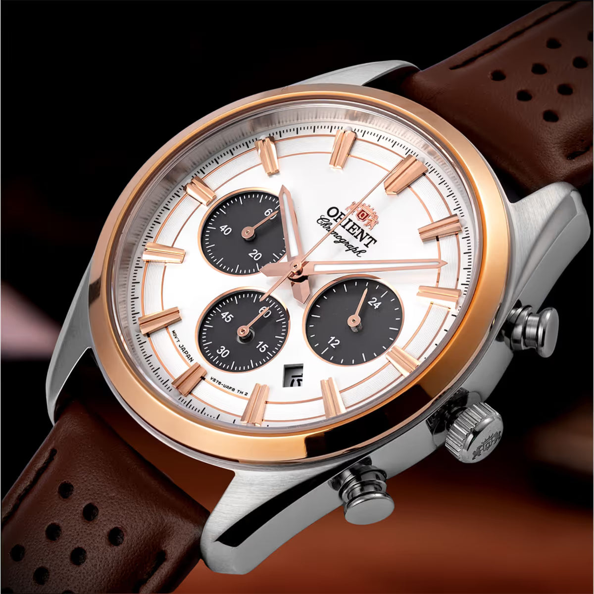Close-up solar chronograph watch with white dial, black subdials, and brown strap