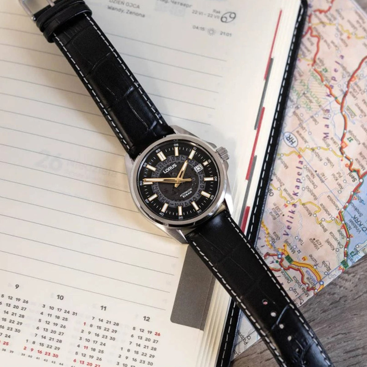 Men's automatic watch on black leather strap with black dial and gold-tone hands.