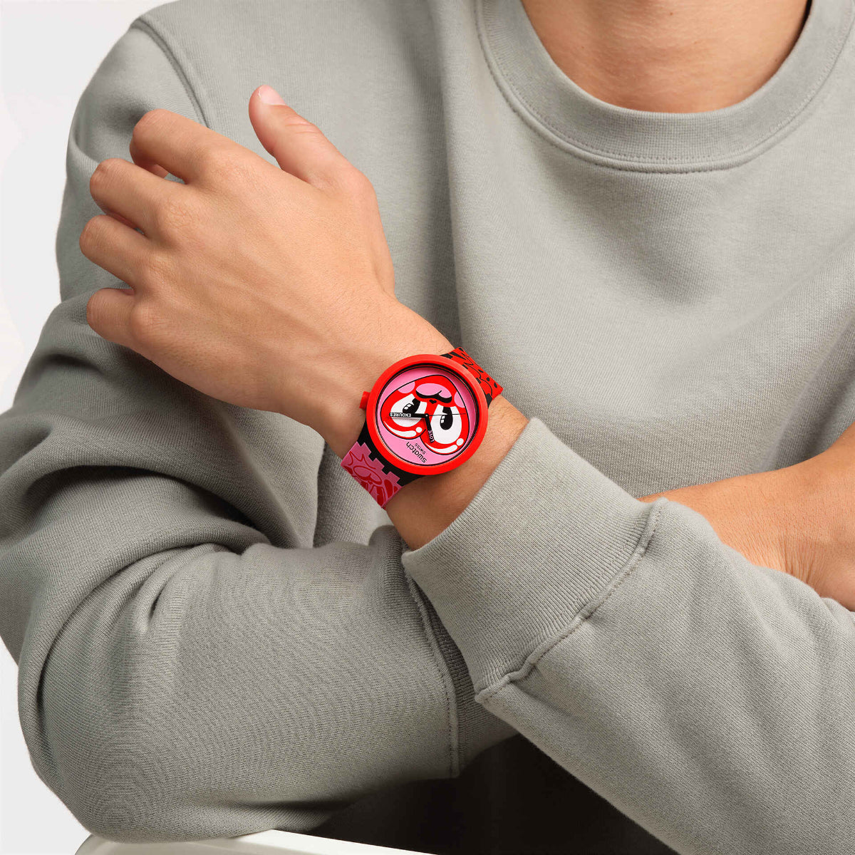 Red silicone strap heart-dial quartz watch on wrist with gray sleeve