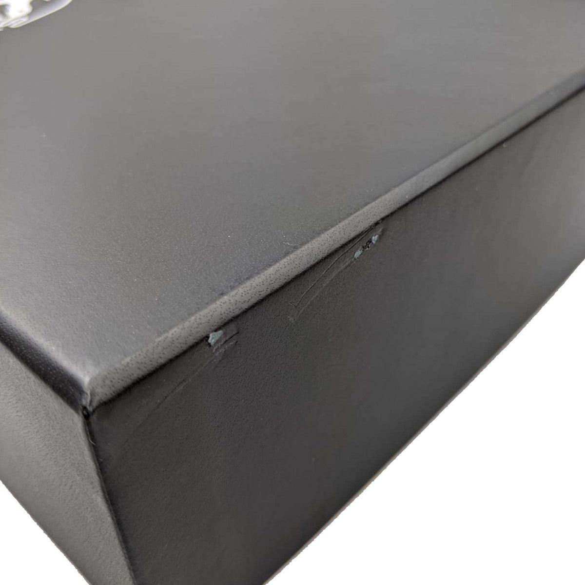 Black watch box with torn cover along the top edge