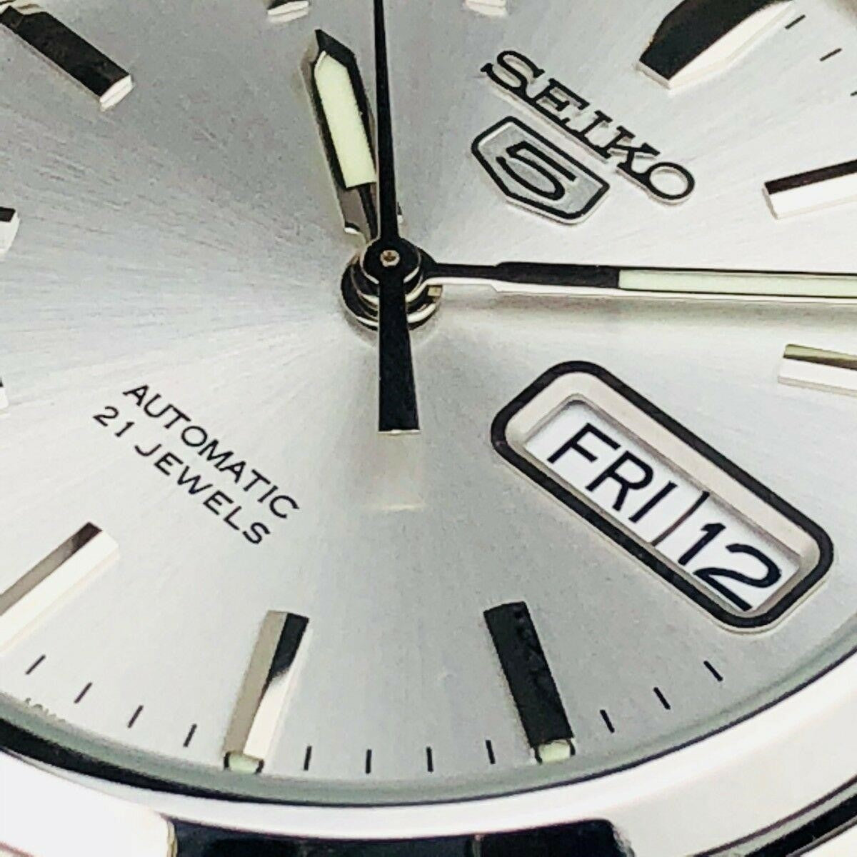 Men's automatic watch close-up, silver dial with date window and baton hour hands