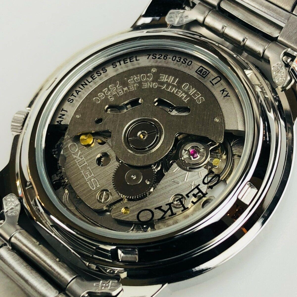 Stainless steel watch caseback with visible mechanical movement and engraved markings