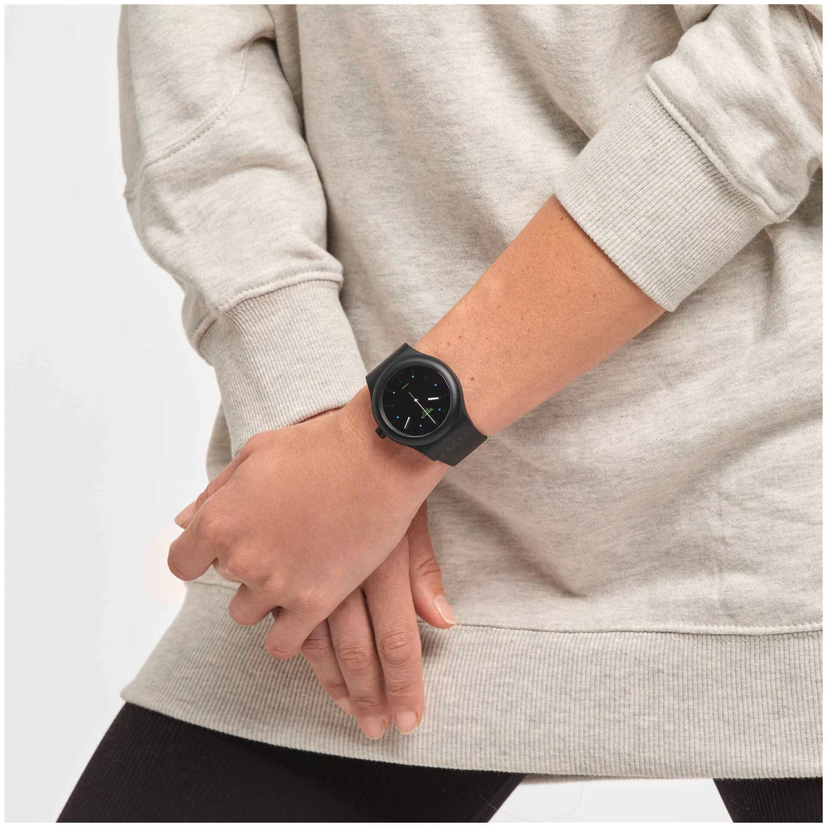 Black automatic wrist watch on wrist with round black dial and rubber strap