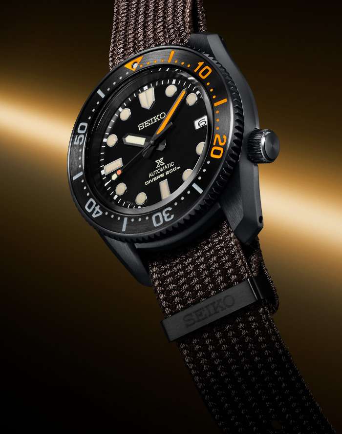 Seiko men's diver wristwatch, black dial with orange bezel markers, brown textile strap