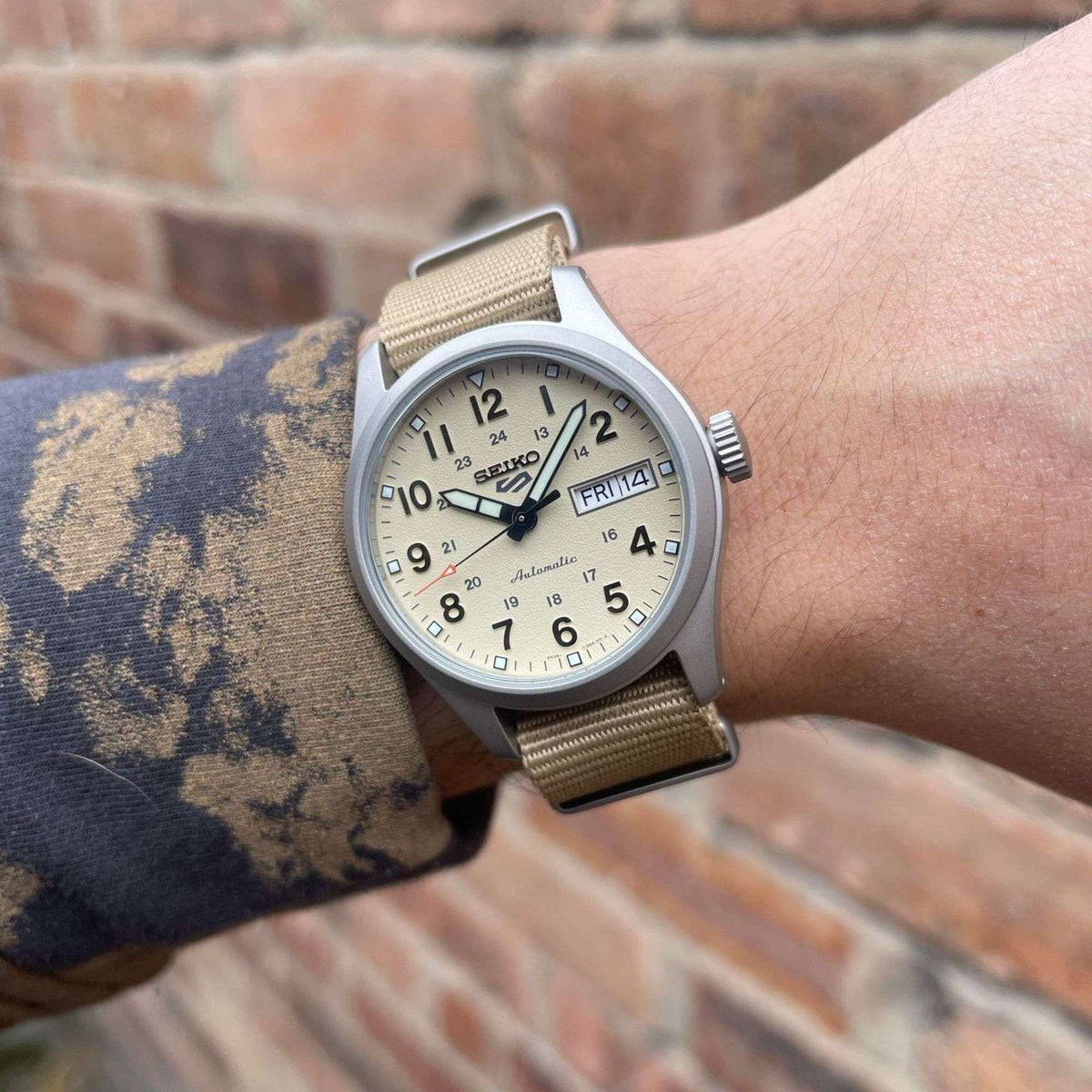 Men's automatic wristwatch worn on wrist, beige dial and beige nylon strap
