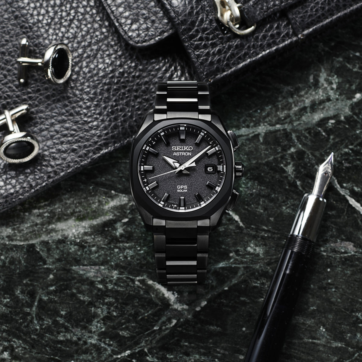 Black men's GPS solar wristwatch with textured dial and metal bracelet, close-up