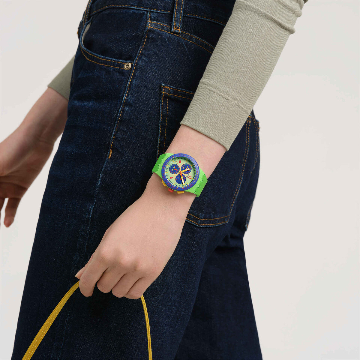 Green silicone strap watch with multicolor circular dial, worn on wrist