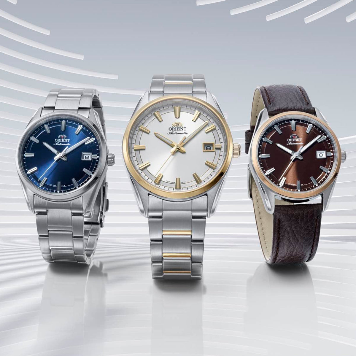 Trio of Orient automatic wristwatches showcasing blue, two-tone silver, and rich brown dial options
