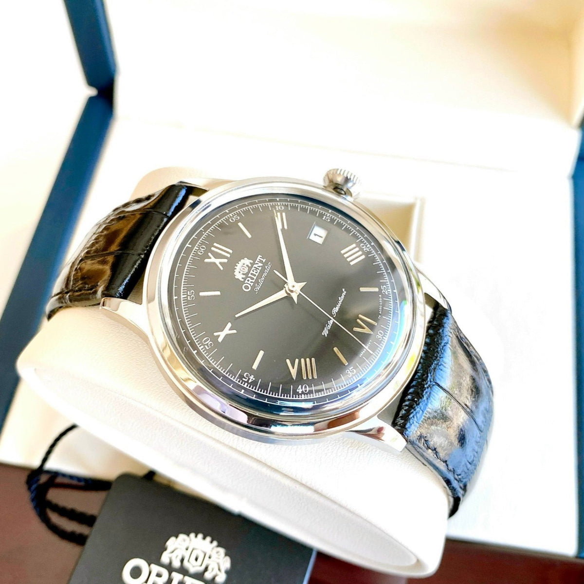 Automatic watch with black dial and dark blue leather strap, in an open box