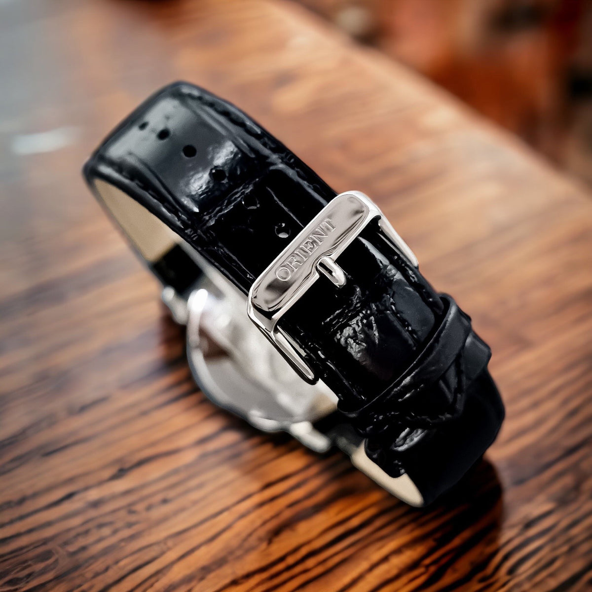 Black leather strap watch with stainless buckle and open-heart movement, round case