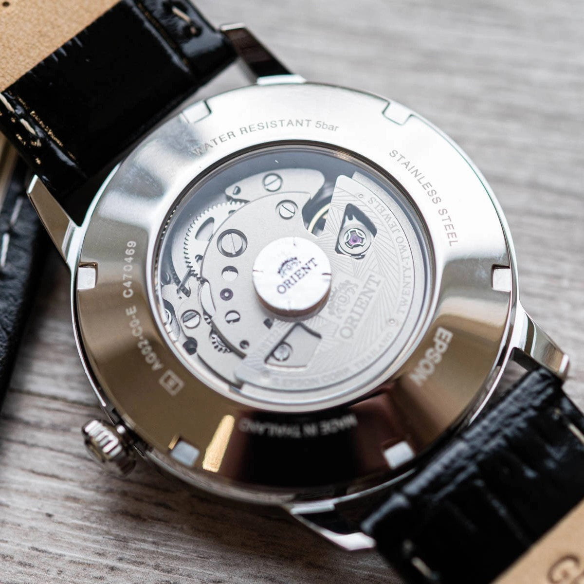 Orient automatic watch case back close-up with metal cover and engraved details