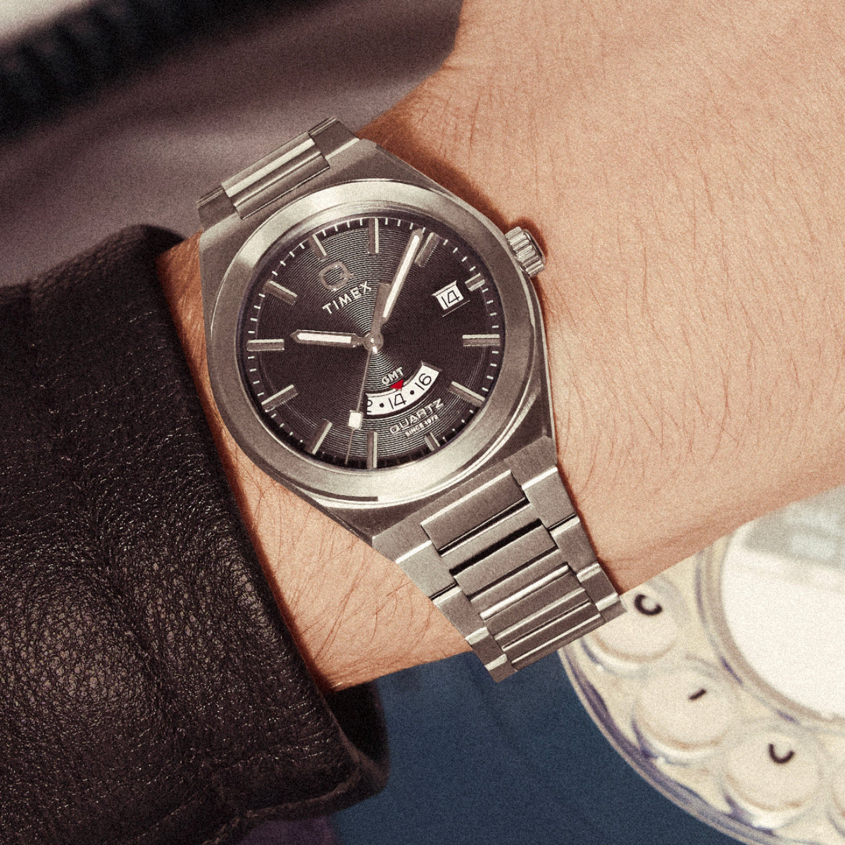 Men’s wristwatch with dark dial, silver case, and stainless steel GMT bracelet