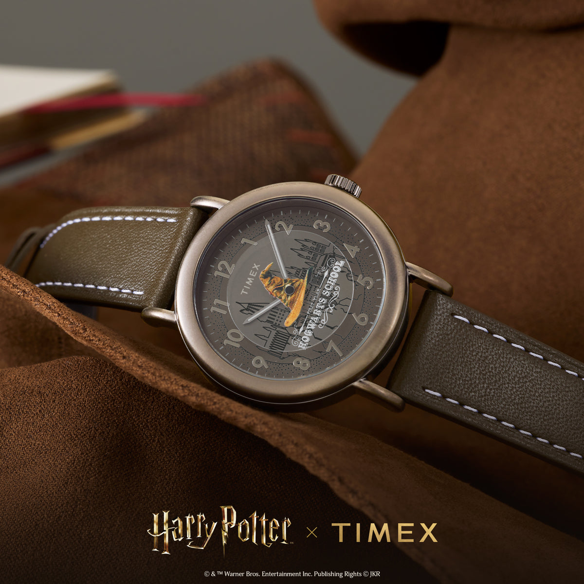 Timex Weekender quartz wristwatch TW2Y77000 on leather surface, brown dial with Hogwarts graphic and brown leather strap