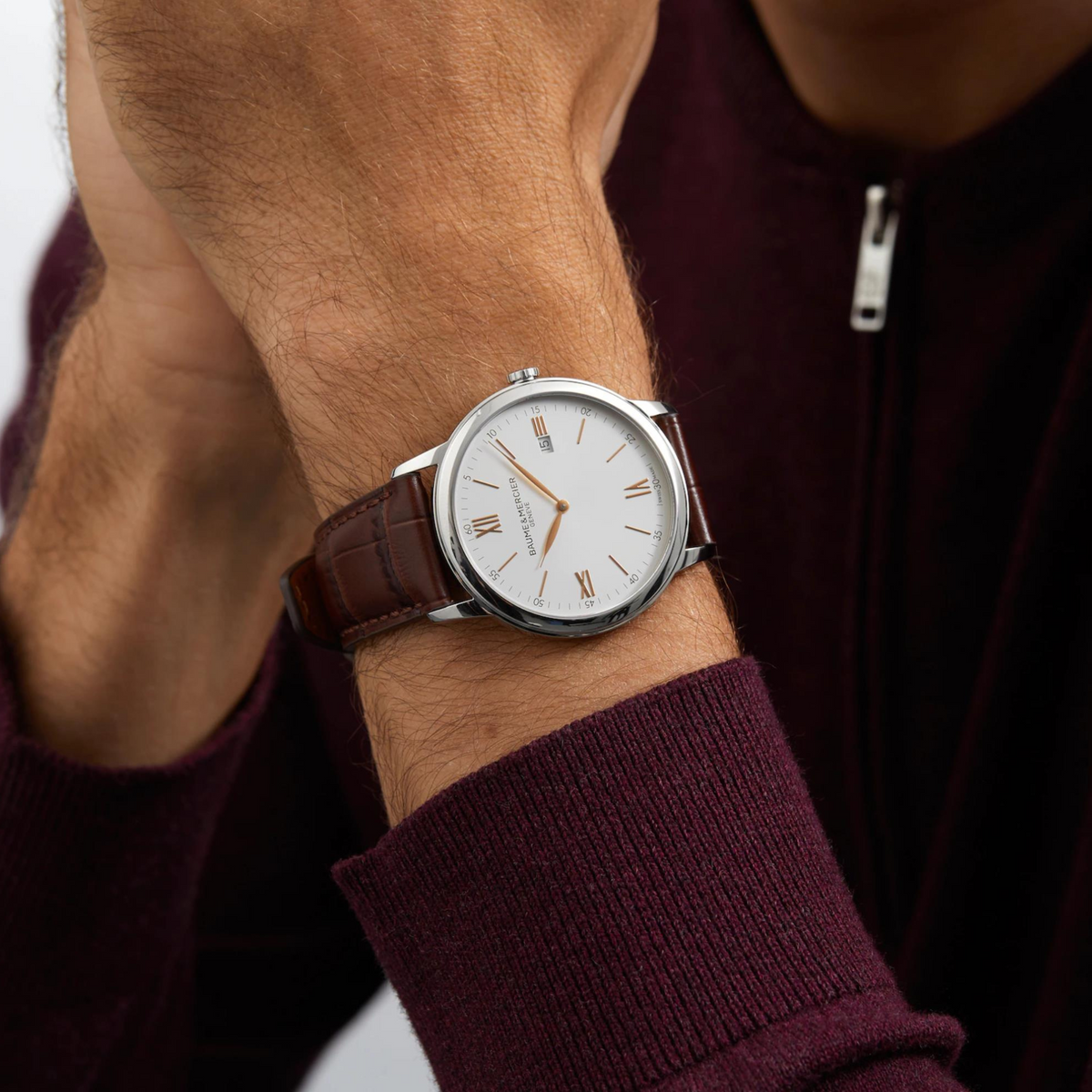Men's quartz watch with brown leather strap on wrist, white dial with Roman numerals