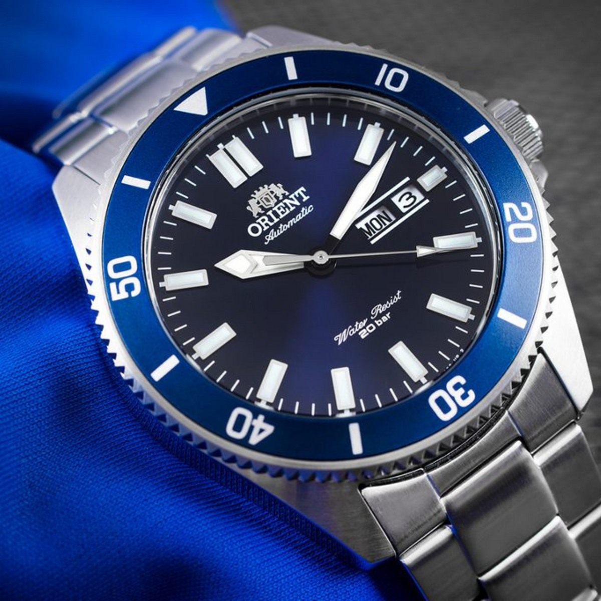 Stainless steel watch with blue dial, large lume-style indices, date display, bezel numbers