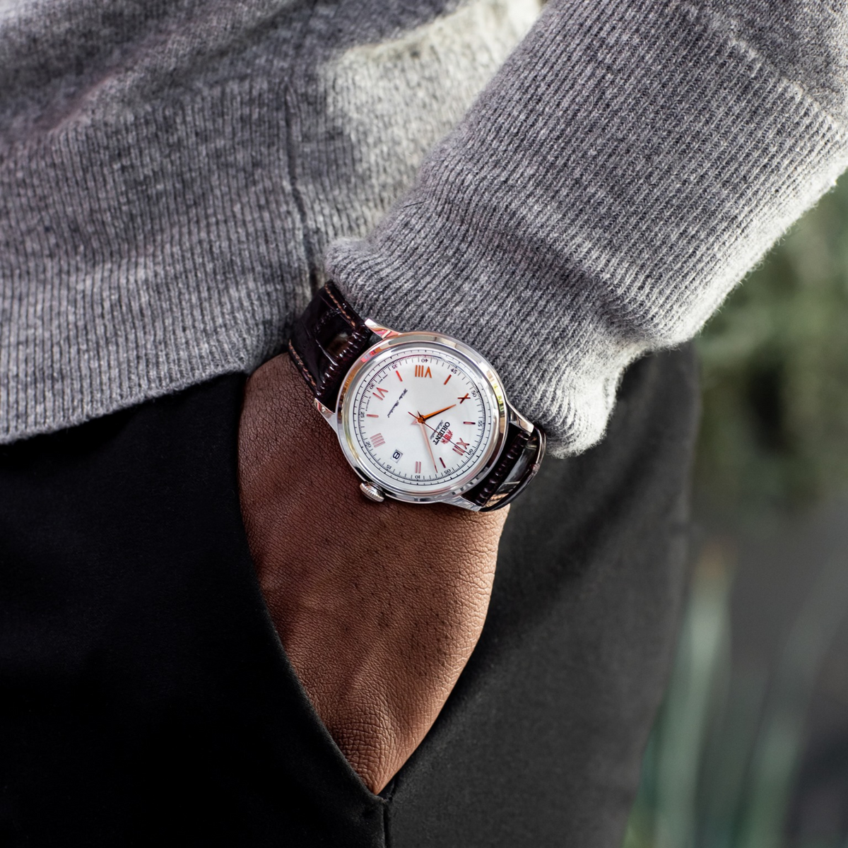 Men's automatic leather watch on wrist: white dial, Roman numerals, brown leather strap