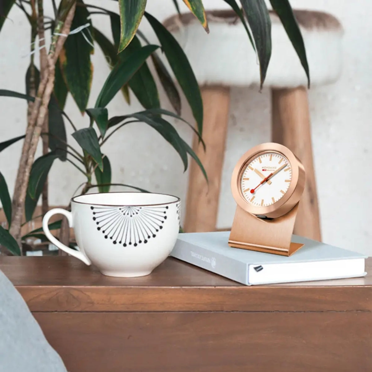 Mondaine Magnet Clock A660.30318.82SBK tabletop view placed on notebook beside coffee mug