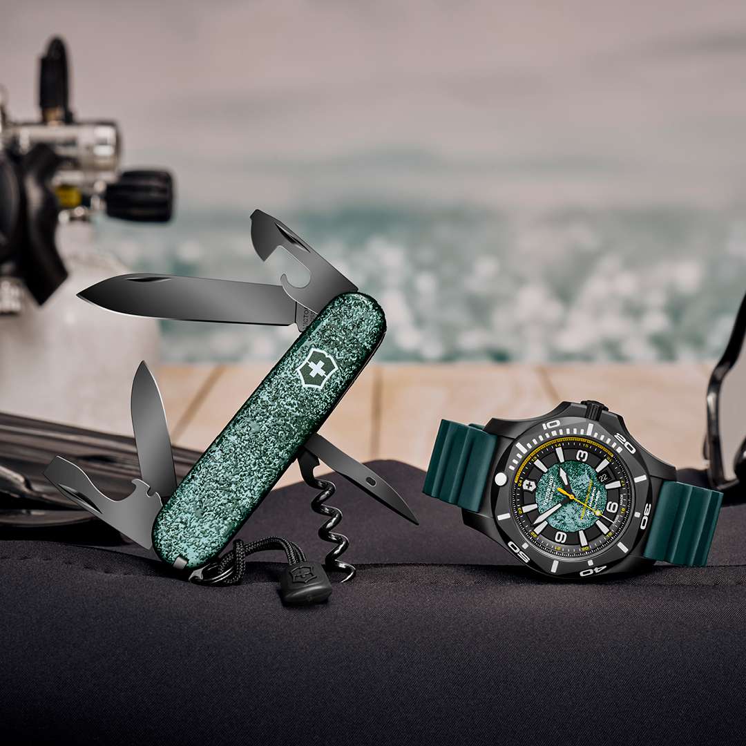 Men's dive watch on dark surface with green dial and dark teal rubber strap