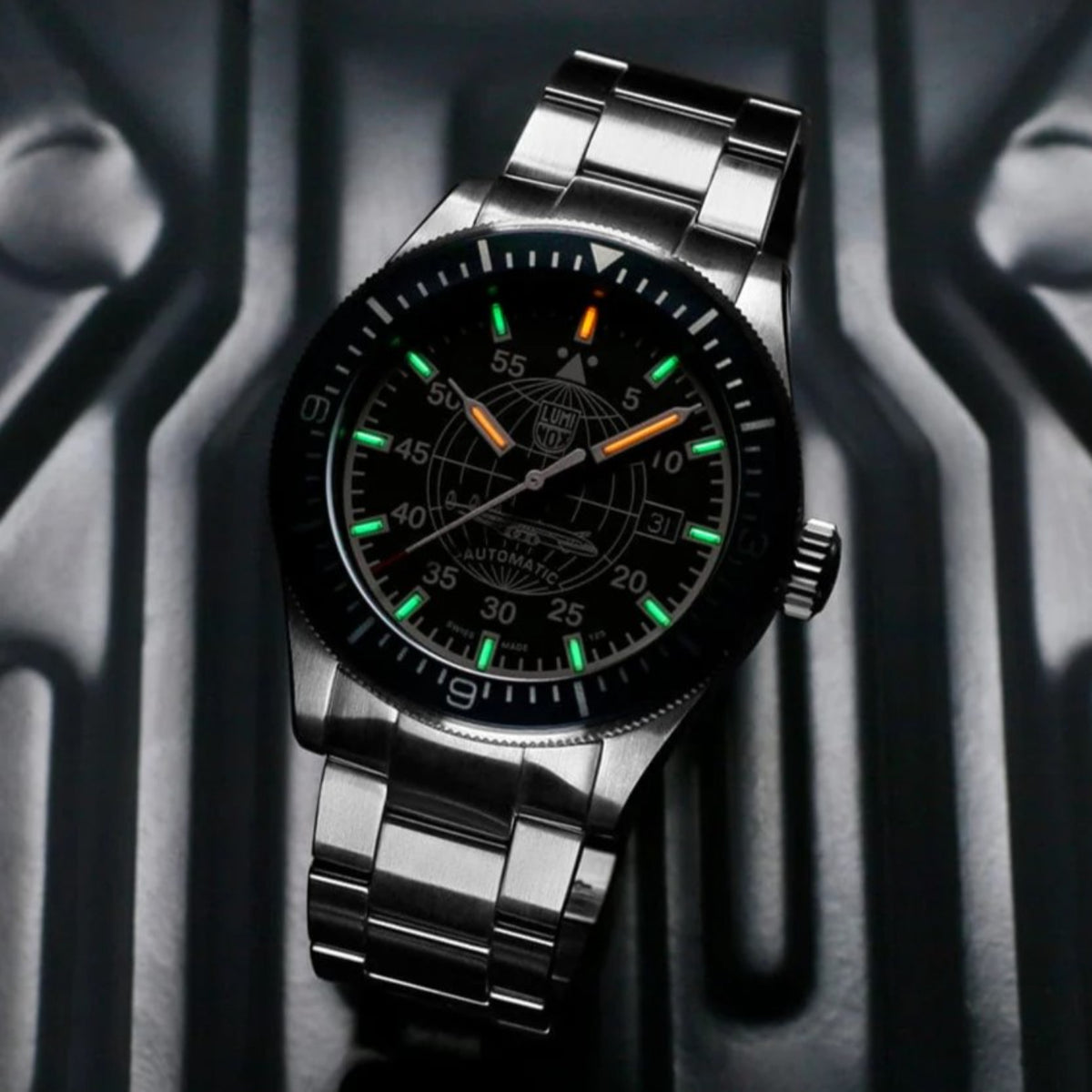 Luminox Automatic stainless steel watch with glowing tritium tubes on a dark background