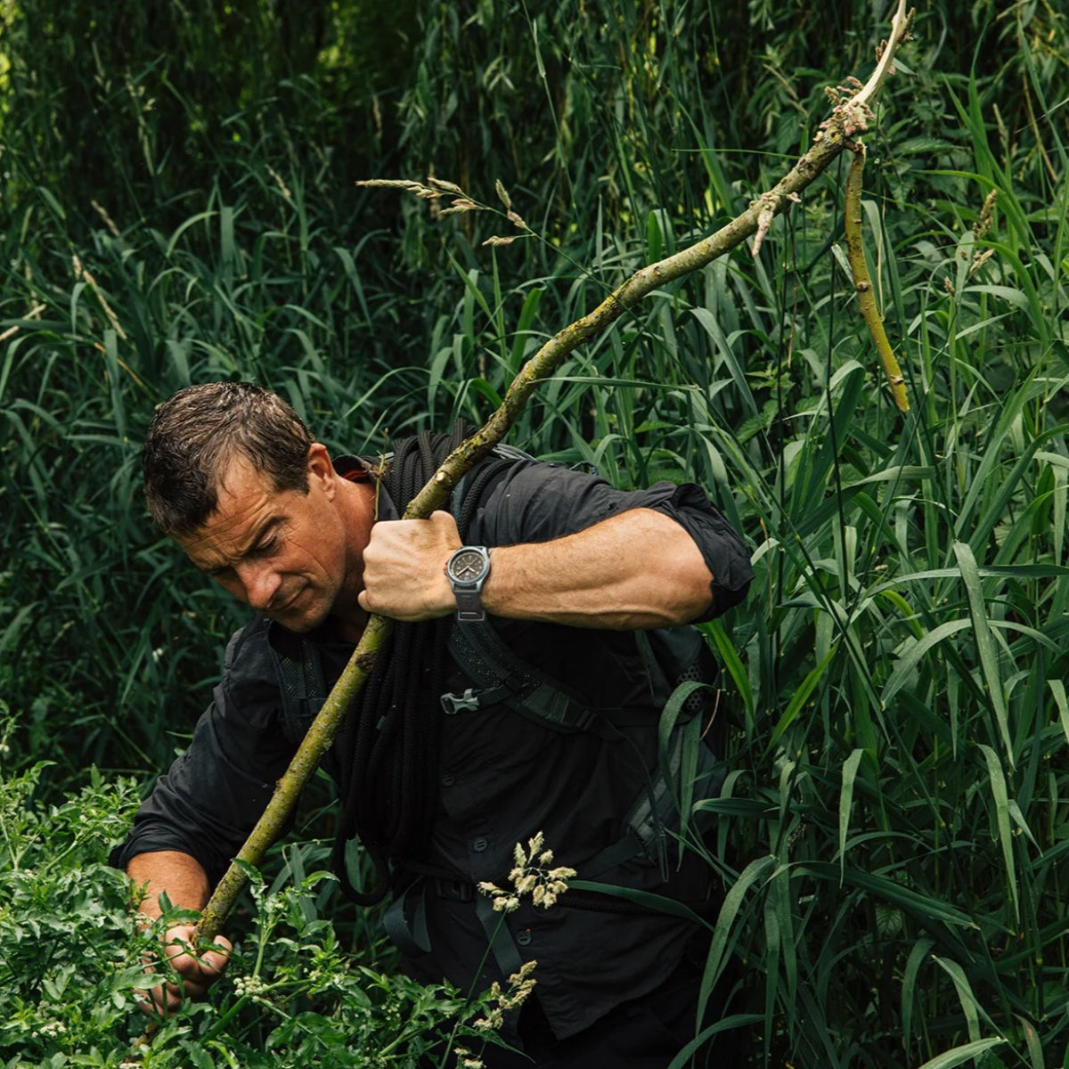 Outdoor action shot of Bear Grylls clearing foliage with the Luminox Bear Grylls Survival XB.3716 visible on his wrist