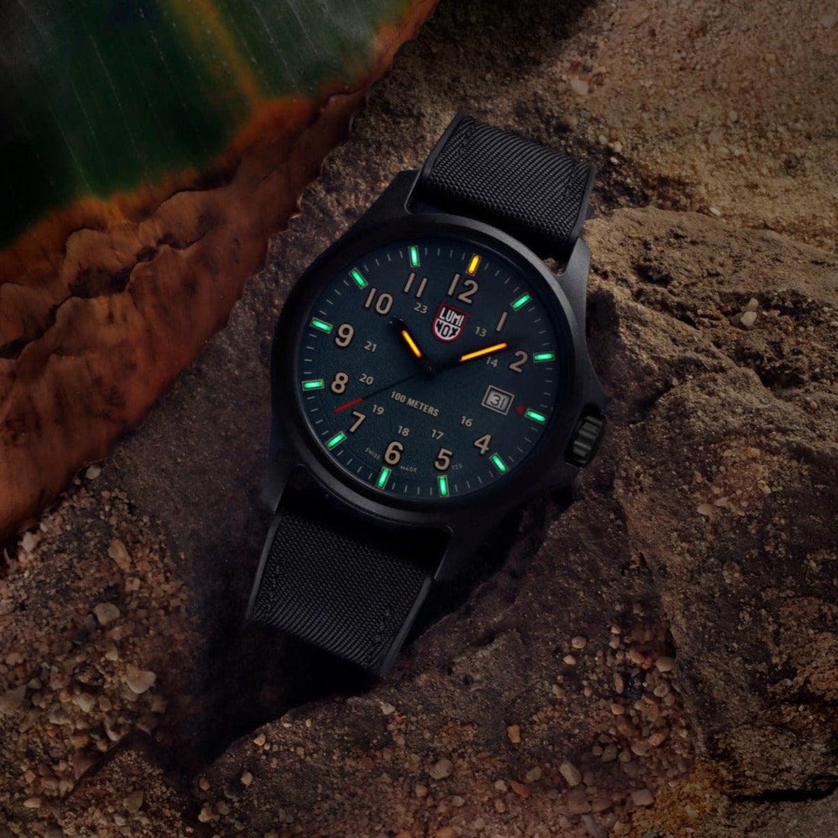 Luminox Atacama Field XL.1977 outdoor watch with glowing tritium tubes placed on a dark rock setting