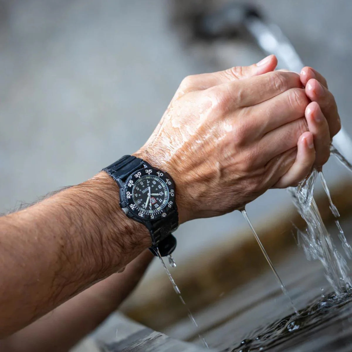 Luminox Navy Seal black dial rubber quartz watch on wrist with water splashes
