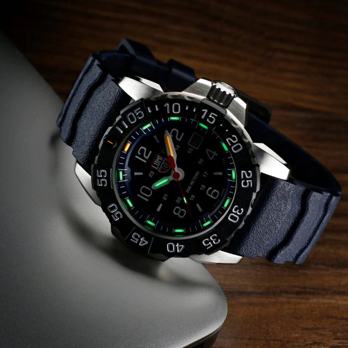Navy blue rubber strap quartz wristwatch with glowing luminous hands and bezel numerals