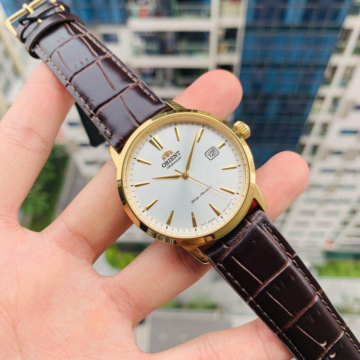 Orient Symphony automatic watch with a white dial and brown leather strap.