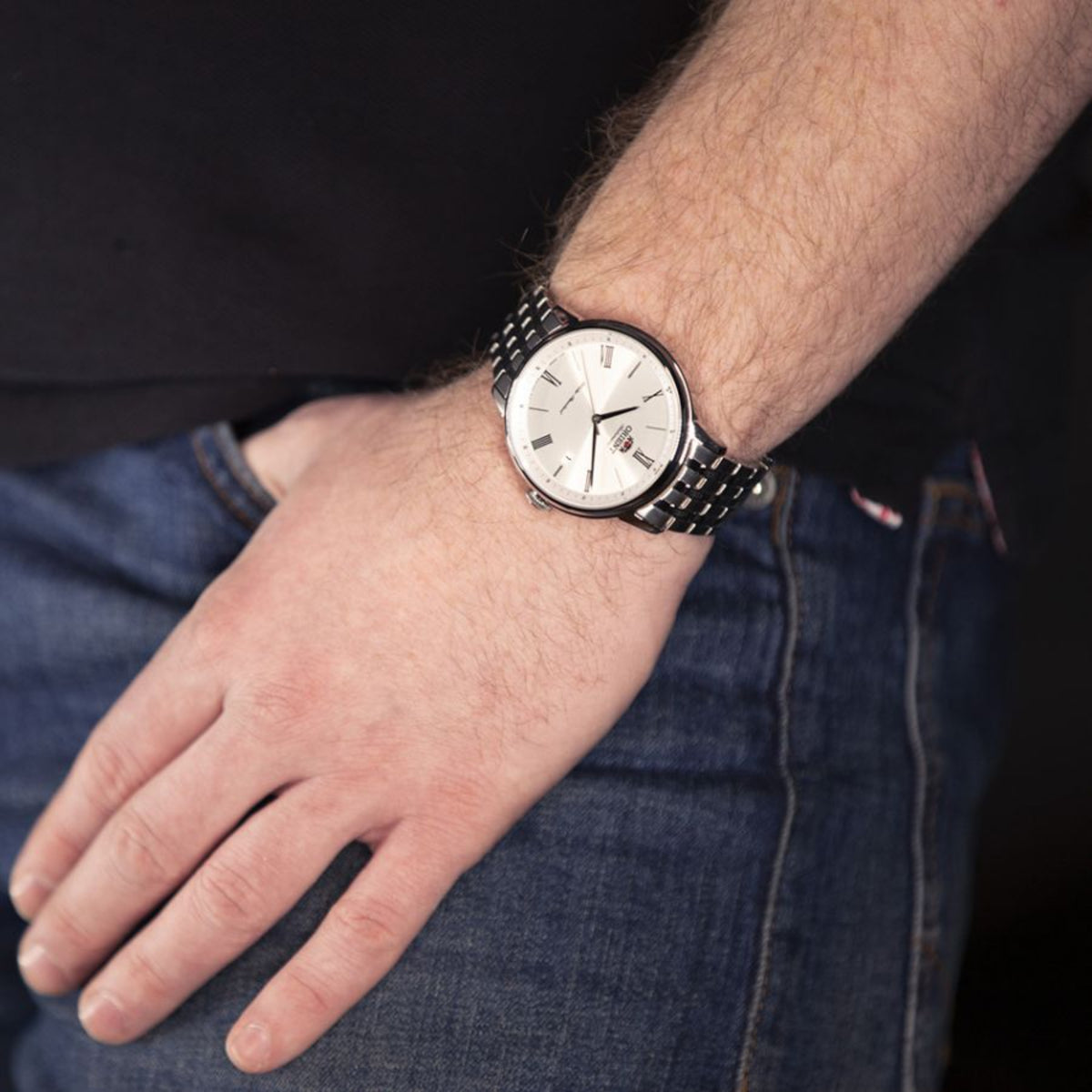 Stainless steel men's automatic watch on wrist with silver dial and link bracelet