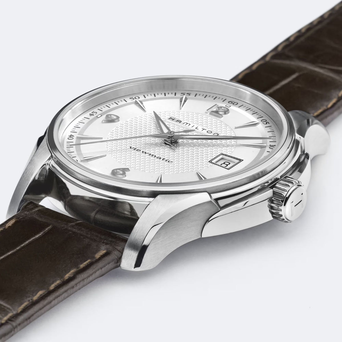 Silver automatic watch case with white dial and brown leather strap detail
