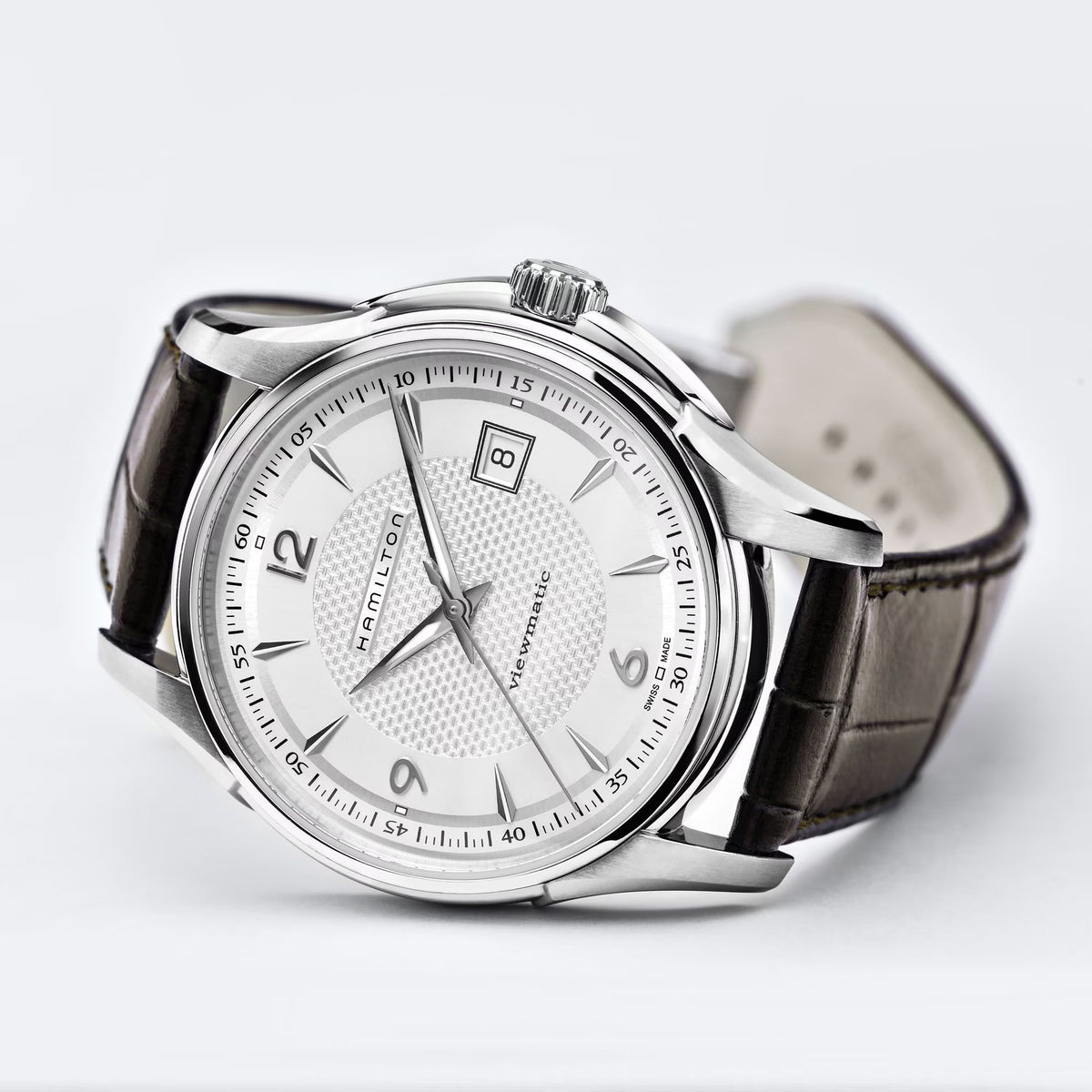 Silver-cased Hamilton watch with textured white dial, date window, and brown leather strap