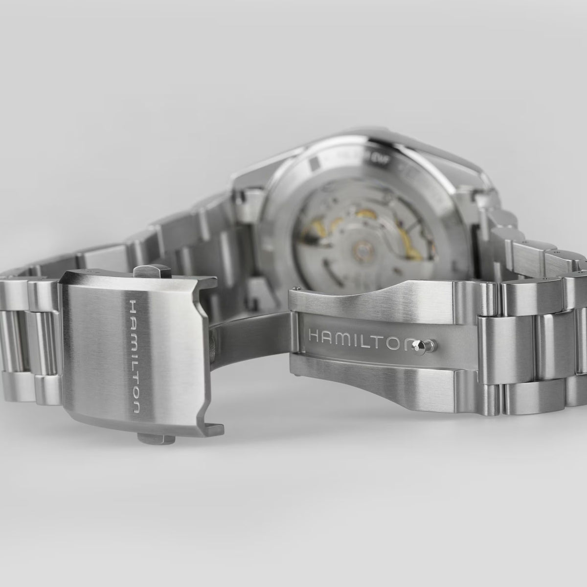 Open folding clasp of a Hamilton stainless steel watch bracelet and exhibition caseback