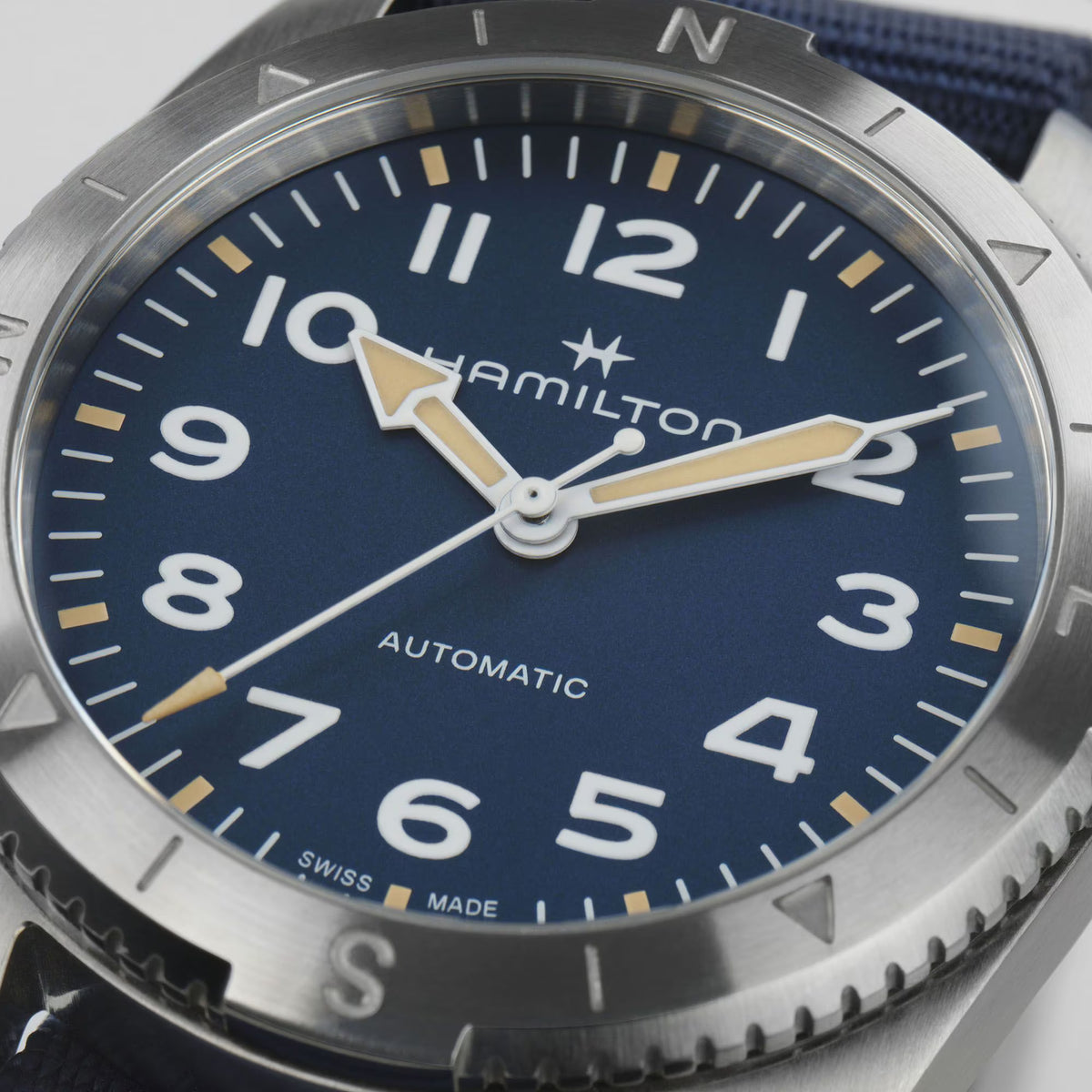 Close-up of blue dial automatic wristwatch with Hamilton logo and gold hour markers