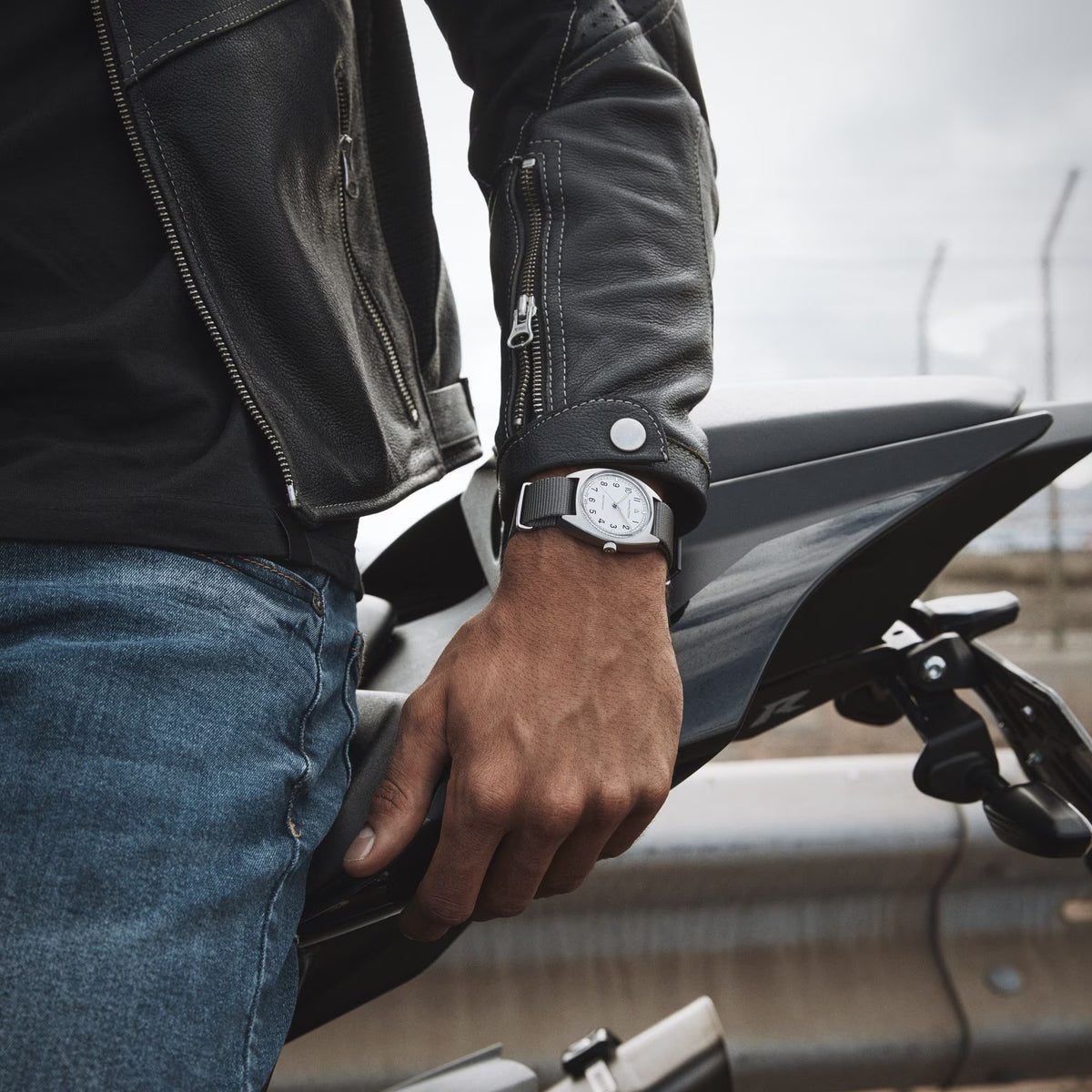 Hamilton Khaki Pilot Pioneer watch with a white dial and grey textile strap, on a wrist