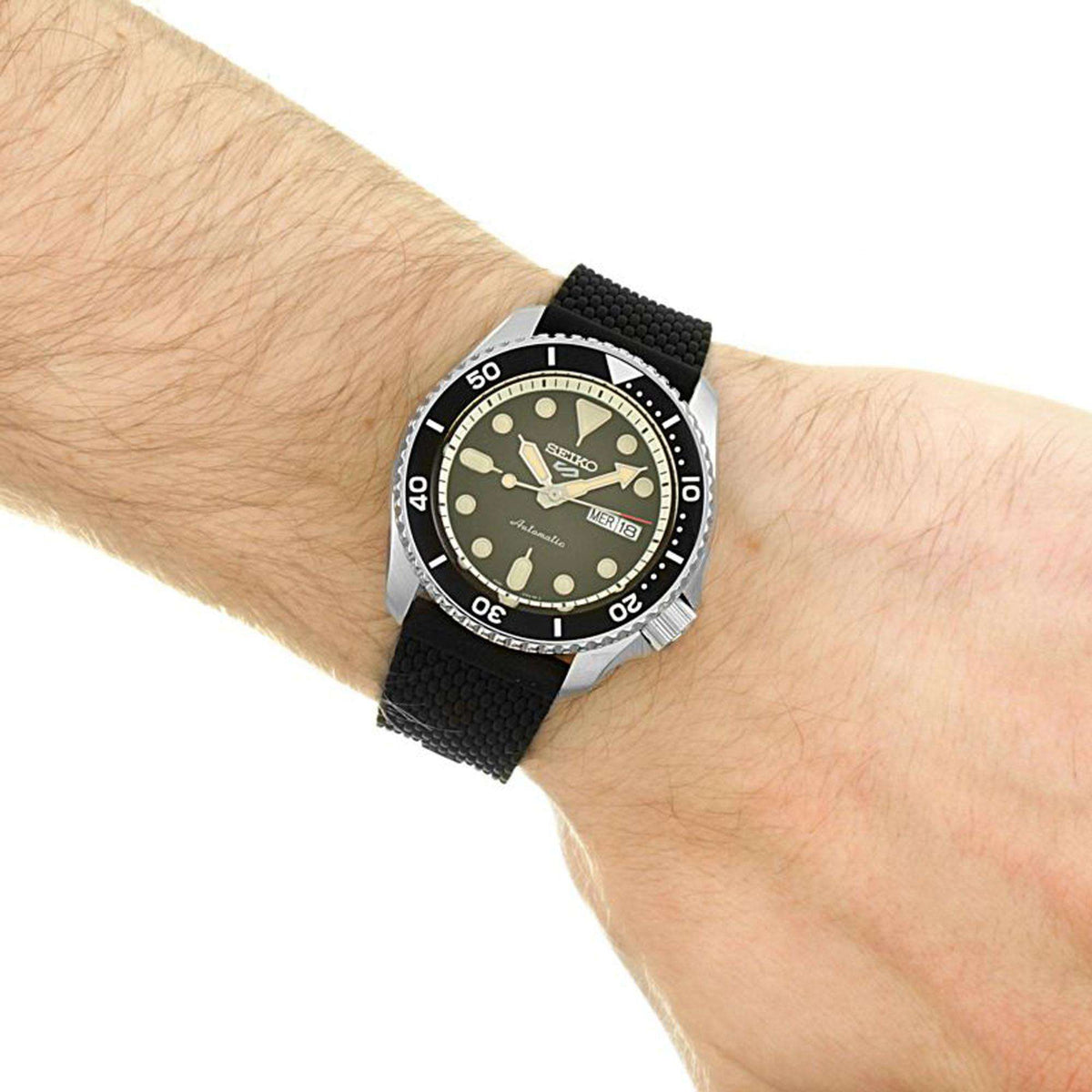 Men's Seiko wristwatch on wrist with black dial, silver bezel, and black strap