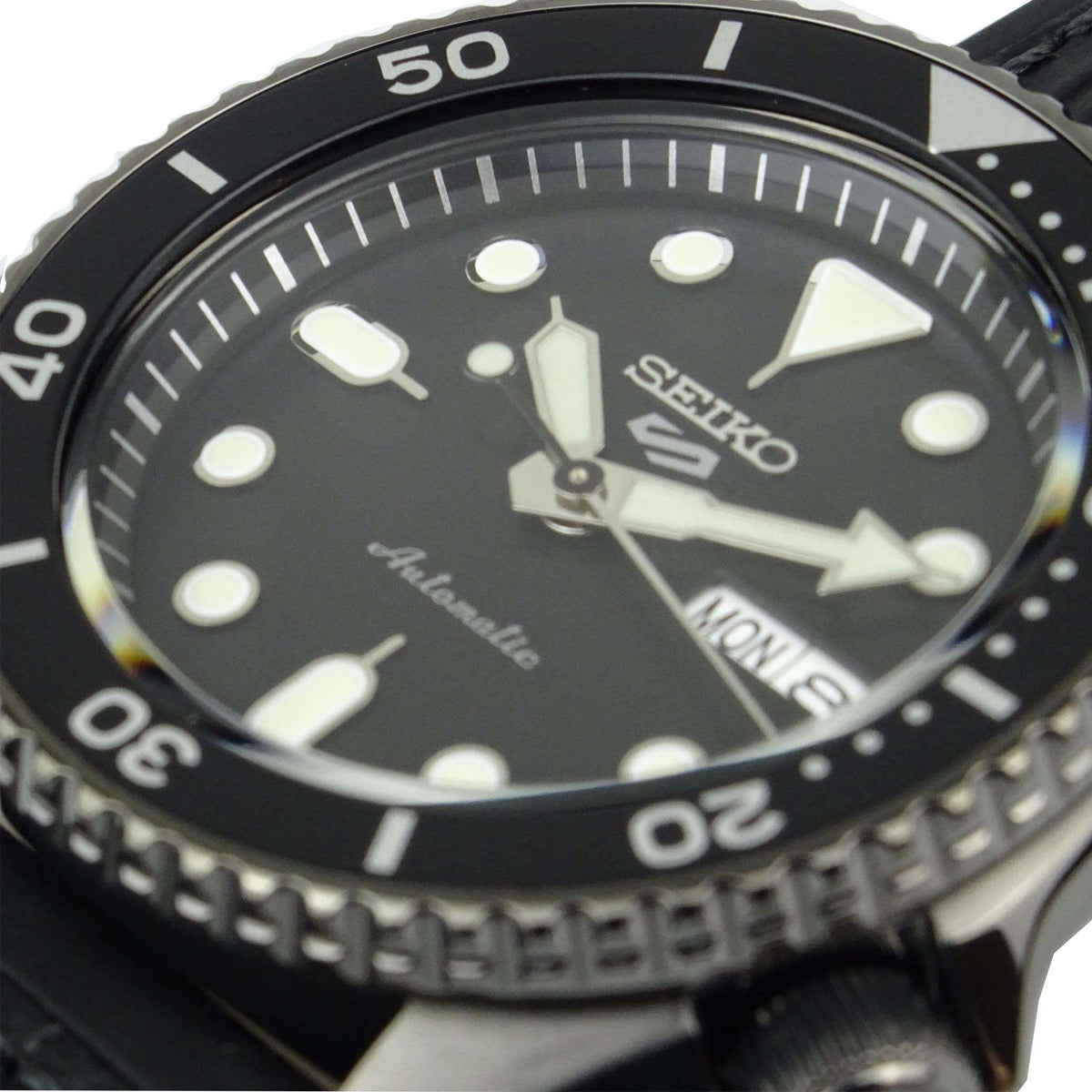 Men's automatic watch dial close-up with Seiko logo, large markers, and date window.