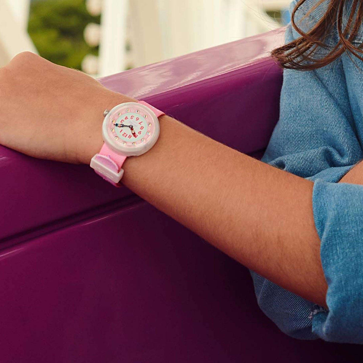 Kids wristwatch on arm: pink dial with pink fabric strap