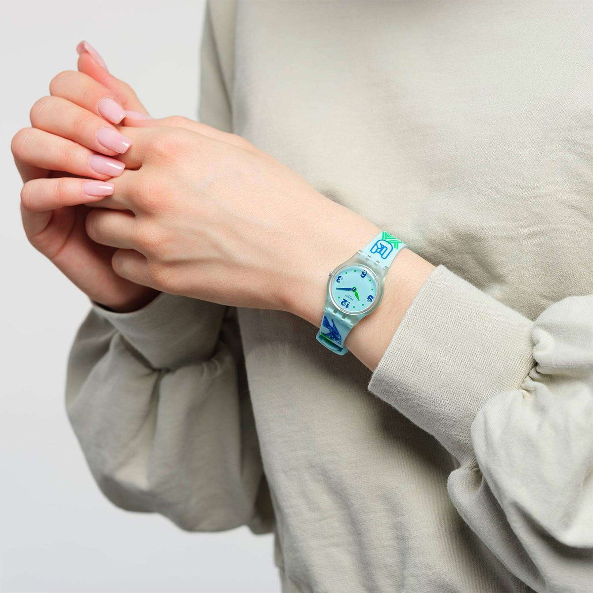 Quartz wristwatch with light blue silicone strap and blue dial on a wrist
