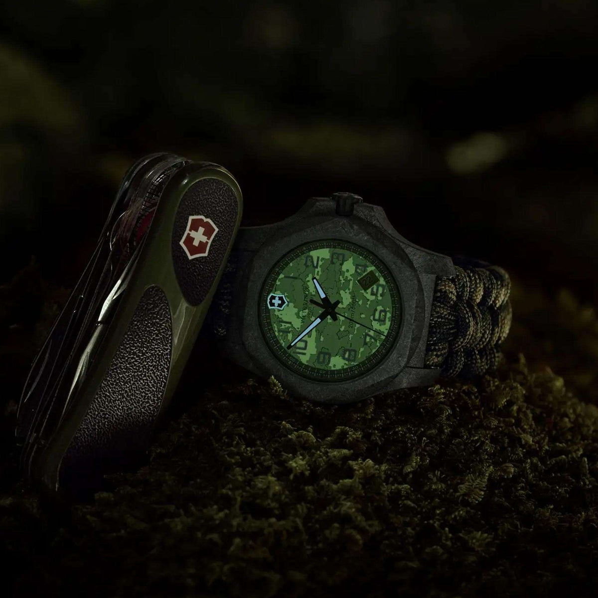 Close-up men’s quartz watch with green camo dial, dark carbon case, paracord strap