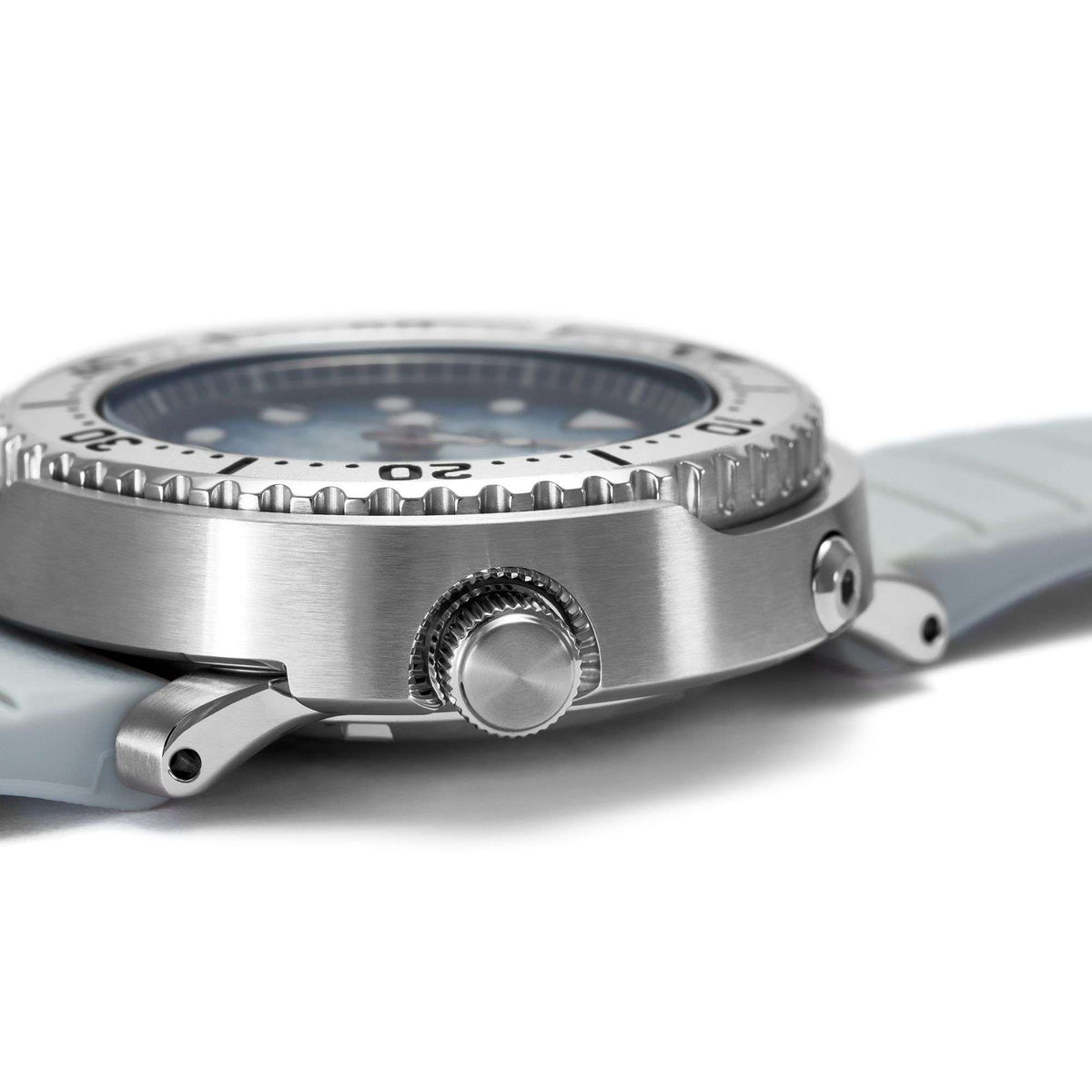 Side view of men's dive watch case with crown and light gray silicone strap