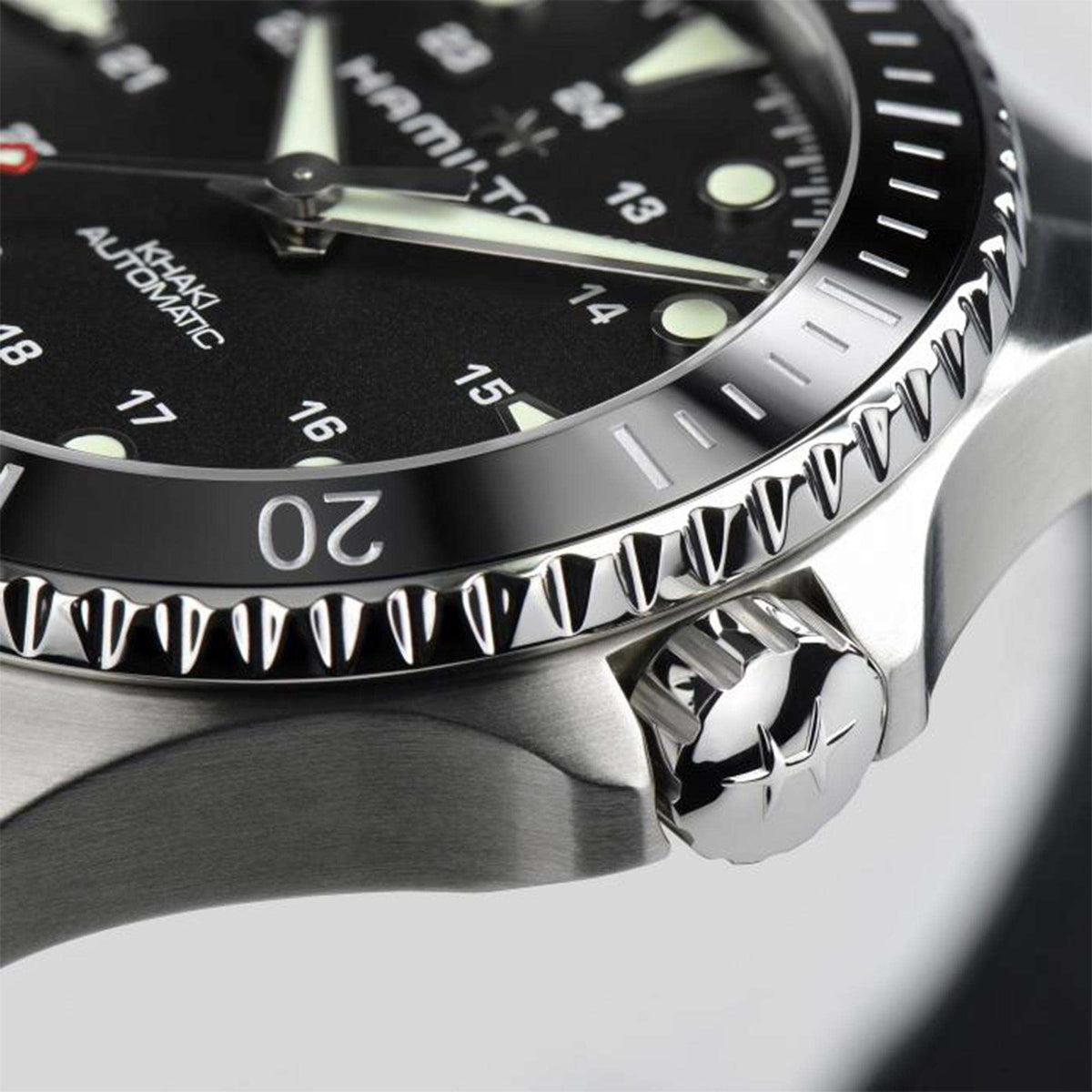 Men's automatic scuba watch with black dial, silver bezel, and metallic crown, close-up