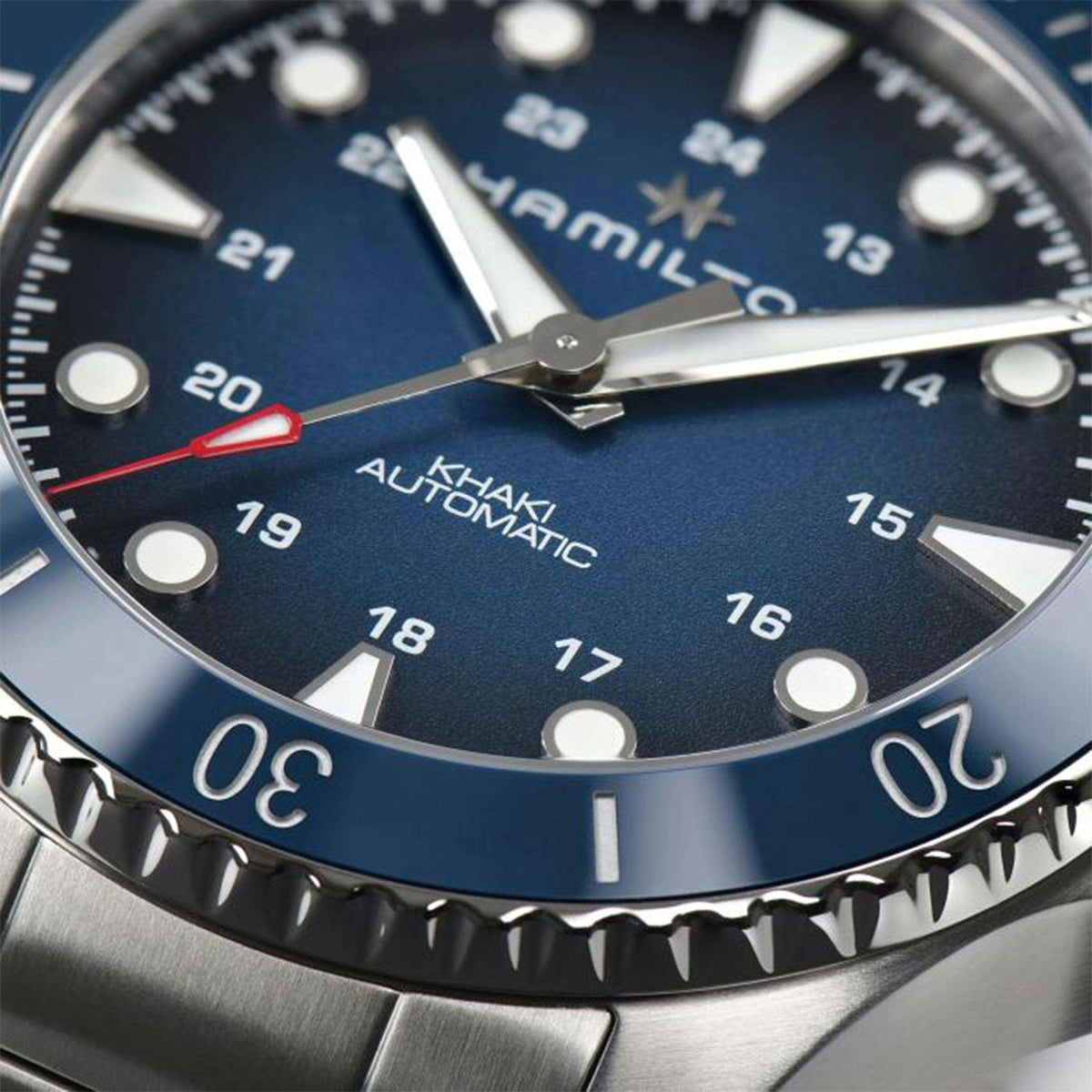 Hamilton H82505140 blue dial with luminous hands and ceramic bezel engraved numerals close-up