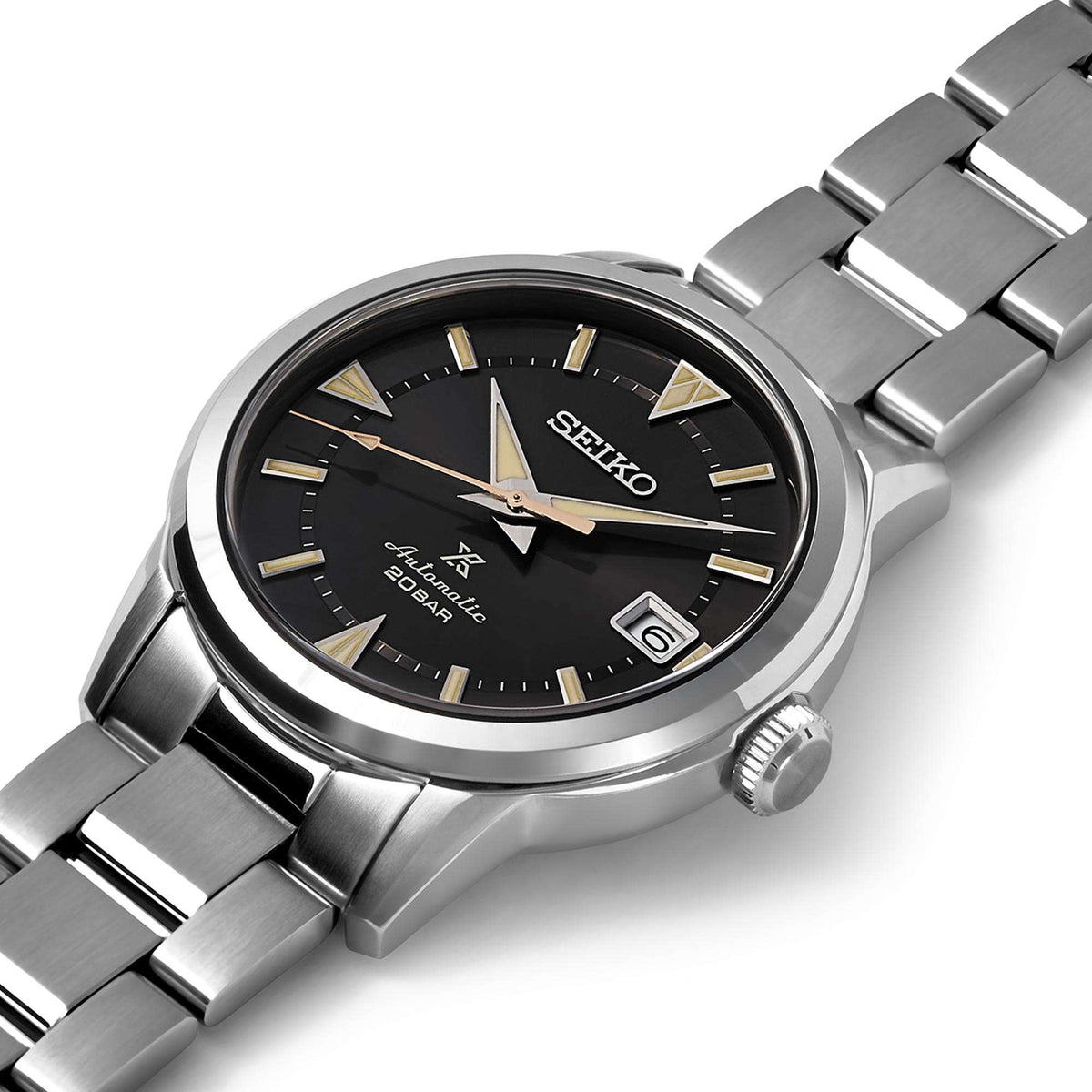 Angled view of men's stainless steel watch with black dial, gold accents, and date window